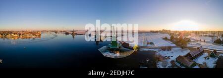 panoramic view over the Zaanse Schans windmill village snow covered during winter, Zaanse Schans wind mills historical wooden mills in the Netherlands. Europe Stock Photo