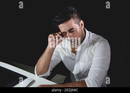 Tired fatigued Asian businessman feeling sleepy and yawning while working night shift Stock Photo