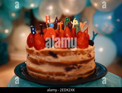 birthday cake with candlesand blue balloons Stock Photo