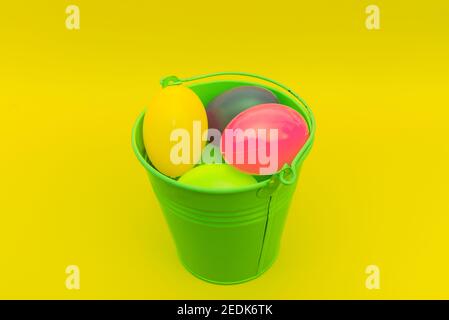 Easter plastic eggs in a metal green bucket indoors studio shot.Eastern concept Stock Photo
