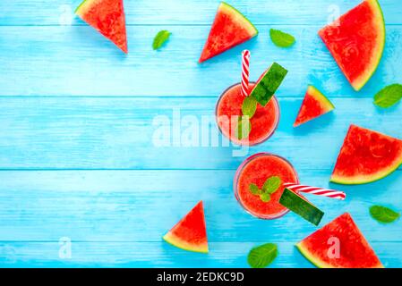 Colorful refreshing cold watermelon juice smoothies drinks in the glasses on light blue wood background with copy space Stock Photo