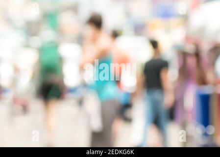 People in colorful clothes walking in outdoor market - blurred bokeh background Stock Photo