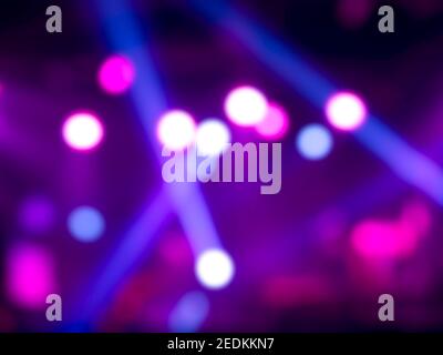 Blurred stage light concert background with colorful beam and laser rays on stage. Defocused entertainment show lighting bokeh. Stock Photo