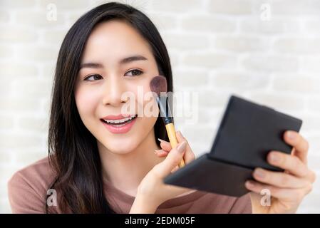 Young beautiful Asian woman professional beauty vlogger or blogger  doing a make up tutorial Stock Photo