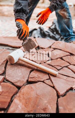 Laying tiles on the floor outside the house - professional tiling during work - decor with stone Stock Photo