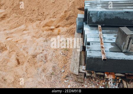 Concrete road curb on wooden pallet at construction site - road construction Stock Photo