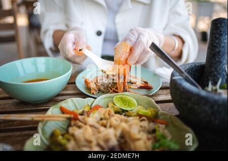 Woman having large prawn in a Thai restaurant closeup Stock Photo