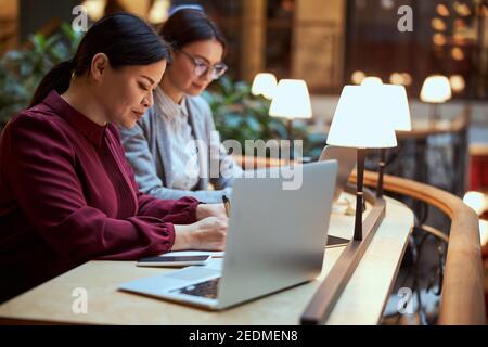 Attentive designer making notes during online lecture Stock Photo