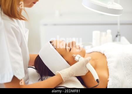 Cosmetologist making procedure of ultrasound Microdermabrasion for young woman Stock Photo