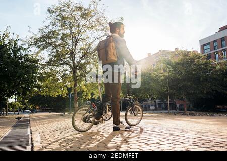 Stock photo of man wearing face mask riding a bike in the city. Stock Photo
