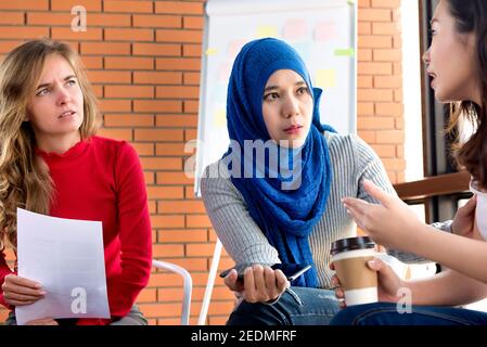 Diverse women sharing problems and support eacher in group meeting Stock Photo