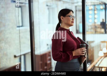 Concentrated Asian businesslady being deep in her thoughts Stock Photo