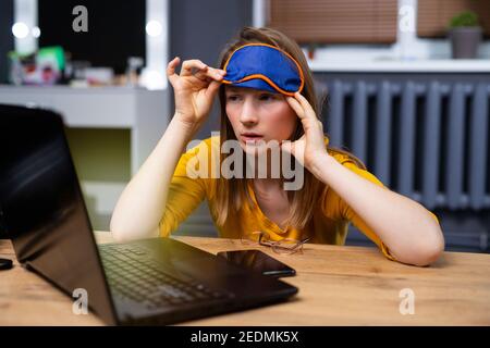 Beautiful young, caucasian, blond-haired, internet addicted woman working bored, sleepless and tired Stock Photo