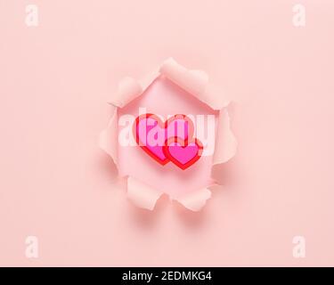 Vivid pink ripped paper with heart on pink background. Minimal abstract love concept. Stock Photo