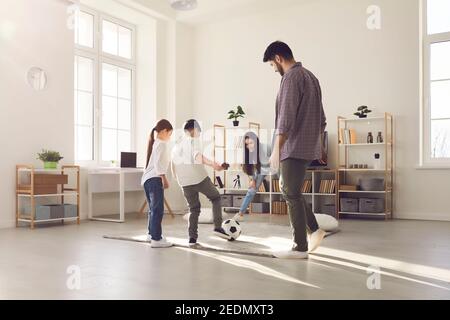 Cheerful father mother and kids daughter and son having fun together at home playing football Stock Photo