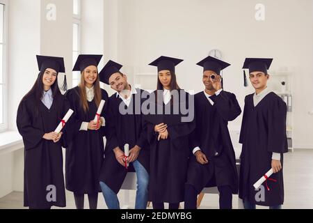 Group of young and cheerful students of different nationalities with diplomas in their hands. Stock Photo