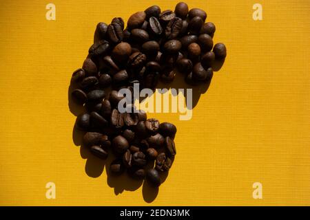 letter c made from roasted coffee beans stylized retro background yellow colored Stock Photo