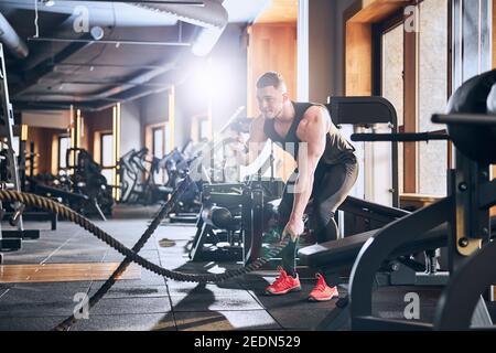 Athletic young man doing HIIT workout in gym Stock Photo