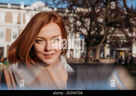 Slow living in city environment, Urban Slow life, mindfulness, enjoying the moment, work-life balance. Young redhead woman enjoying the sun and Stock Photo