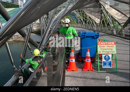 21.01.2021, Singapore, , Singapore - Workers in work clothes and wearing mandatory face masks to protect against infection with the coronavirus (Covid Stock Photo