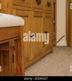 solid oak sideboard dresser base three door base unit  with dark metal knob handles magazine article Stock Photo