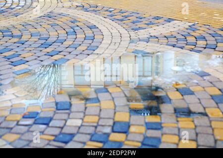 Reflection of a building facade in a puddle on the asphalt Stock Photo