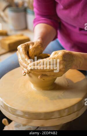 female potter shaping a vase from clay in a pottery workshop , Germany Stock Photo