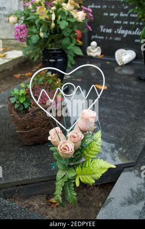 Gravestone with flowers at a graveyard with mom written into a heart Stock Photo