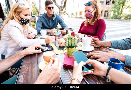 Bored people using mobile smart phones at coffee bar - New normal gathering concept with worried people sharing content online on social media network Stock Photo