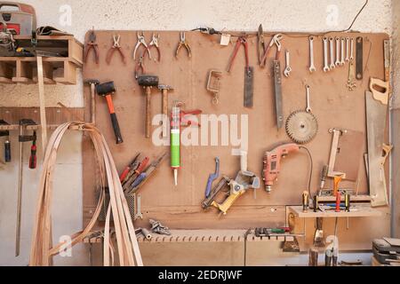 Various tools hang on a wall in a carpentry workshop Stock Photo