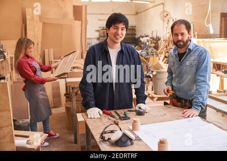 Craftsmen team with trainers and apprentices in the carpentry workshop Stock Photo