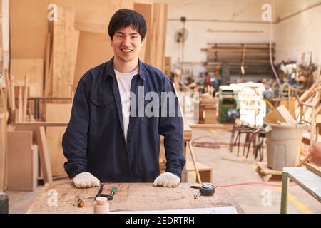 Young man is doing craftsman training as a carpenter in the carpentry workshop Stock Photo