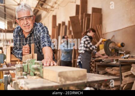 Craftsmen as experienced master planing wood in the joinery workshop Stock Photo