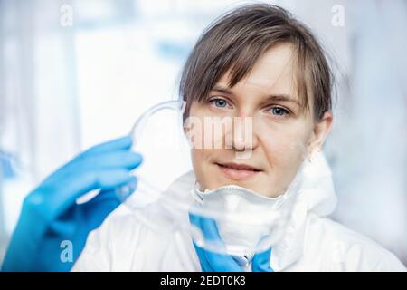 Coronavirus exhausted face doctor happy nurse taking of corona virus protective mask uniform. Concept safety medical professional. Stock Photo