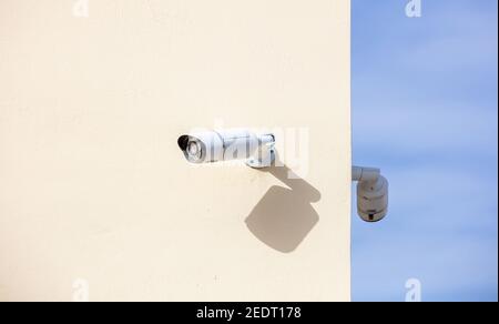 CCTV Cameras, Security system. Surveillance cams on painted wall, bkue sky background, copy space Stock Photo