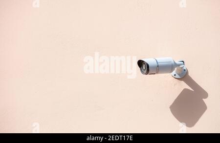Security Camera CCTV. Surveillance cam isolated on painted wall background, copy space Stock Photo