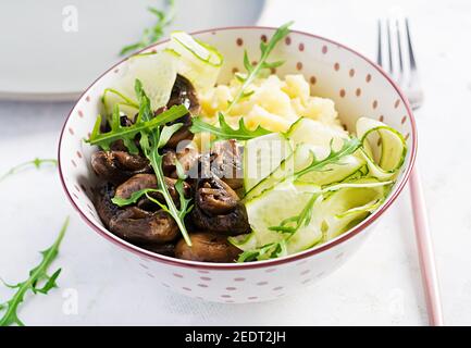 Healthy vegan lunch with mashed potatoes and roasted mushrooms with fresh cucumber. Vegan, vegetarian meal. Stock Photo