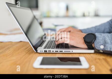 Closeup on man using his laptop at home Stock Photo