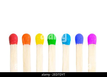 Vertical row of seven matches with match heads painted in rainbow colors isolated on white background. Stock Photo