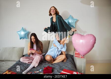 Three lovely women having fun at their karaoke party Stock Photo