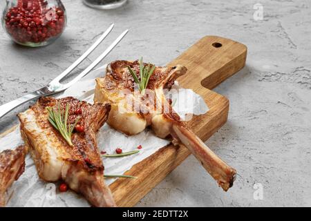 Grilled rack of lamb served on a wooden board Stock Photo