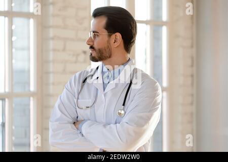 Thoughtful young male doctor looking in distance. Stock Photo