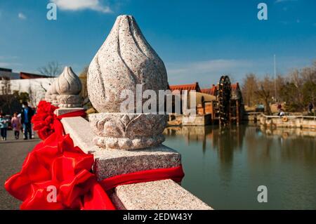 Bridge at the Guangfulin Relics Park in Shanghai’s Songjiang District, China, with a waterwheel in the background. Stock Photo