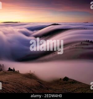 Beautiful sunset on the hill above clouds Stock Photo