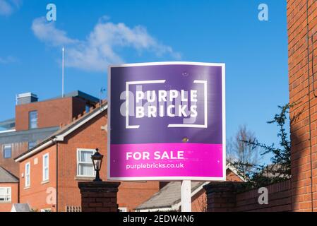Purple Bricks for sale sign outside house Stock Photo