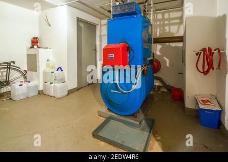 Old blue Buderus G 105 oil heating boiler with red Ray burner constructed in 1992 Stock Photo