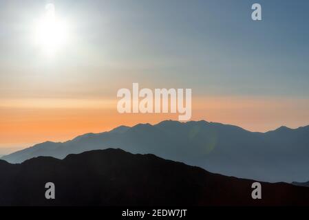 silhouettes of mountain ranges at sunrise background image Stock Photo