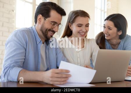 Happy three european colleagues business people working on computer. Stock Photo