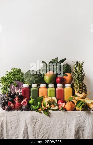 Variety of fresh colorful smoothies for detox weight loss diet. Juices in vacuum bottles with fruit, vegetables and greens ingredients on tablecloth, copy space. Vegan, vegetarian, clean eating food Stock Photo