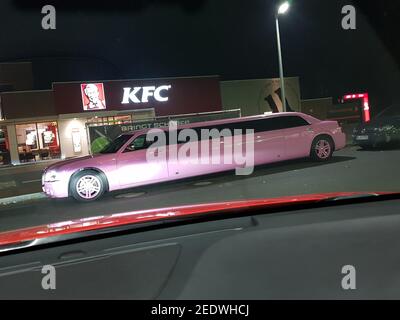 VELBERT, NRW, GERMANY - NOVEMBER 17, 2018: A pink stretch limousine waits for the arrival of passengers in front of a Kentucky Fried Chicken restauran Stock Photo